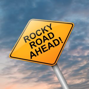 Rocky road sign with darkening sky